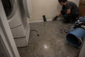 murky water from washing machine overflow causing gray water damage in laundry room