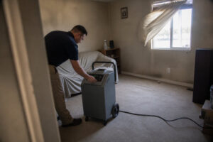 technician setting up hydroxyl generator for odor removal in smoke damaged living room