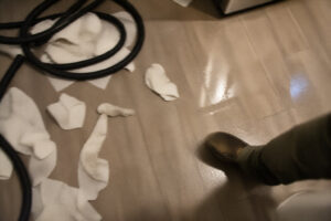 floor with water residue and tools partially visible during cleanup process