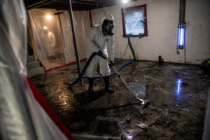 technician extracting contaminated sewage water during basement backup cleanup in South Jordan Utah