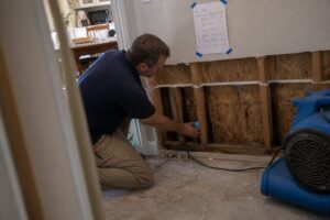 Wall cavity open with wet insulation exposed for structural drying - South Jordan, UT