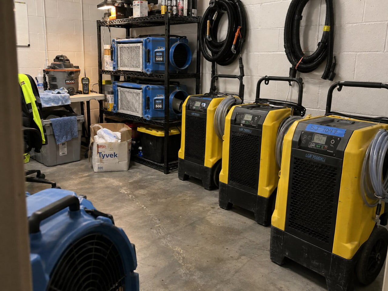 Interior of True Day Water Damage Restoration South Jordan office showing LGR dehumidifiers, HEPA air scrubbers, and drying equipment staged for dispatch